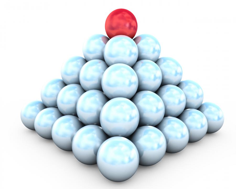 Pyramid of white balls and red on top leadership stock photo Slide01