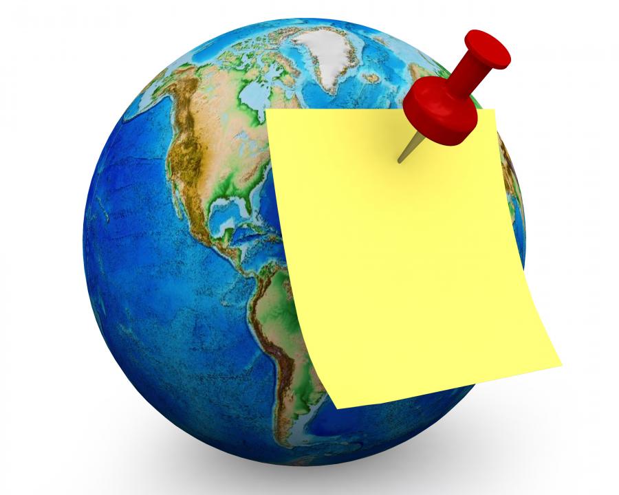 Sticky note with red pin on globe stock photo Slide01