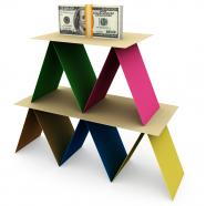 3d colored card pyramid with dollar bundle on top stock photo