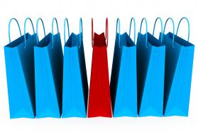 7 shopping bags with one red and 6 blue stock photo