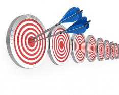 Arrows hit on target board showing concept of meeting goals stock photo
