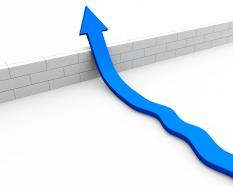 Blue arrow jumping over concrete wall for success stock photo