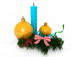 Blue candle with two golden decorative balls with bow and green grass stock photo