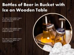 Bottles of beer in bucket with ice on wooden table