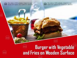 Burger with vegetable and fries on wooden surface