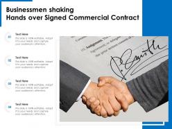 Businessmen shaking hands over signed commercial contract
