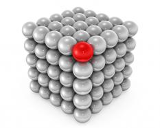 Cube made of silver metal balls with red ball in corner as leader stock photo