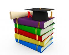 Degree with graduation cap residing above books stock photo