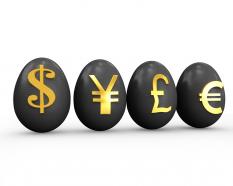 Dollar yen pound euro currencies symbols on eggs stock photo