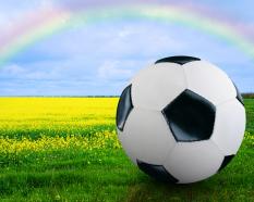 Football under the rainbow and over grass stock photo