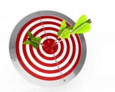 Green arrows hitting on center of red target board stock photo