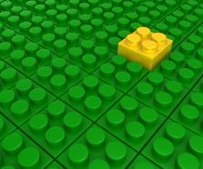 Green lego blocks background with one yellow block as leader stock photo