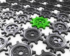 Grey gears with one green gear as leader stock photo