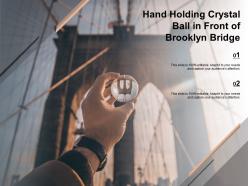 Hand holding crystal ball in front of brooklyn bridge