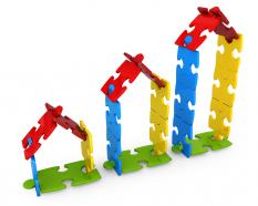 Huts made from puzzle pieces showing concept of growth stock photo