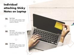 Individual attaching sticky notes on laptop