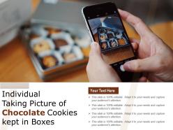 Individual taking picture of chocolate cookies kept in boxes