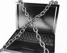 Laptop surrounded with chain stock photo