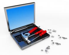 Laptop with hammer screwdriver for repair work stock photo