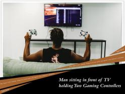 Man sitting in front of tv holding two gaming controllers