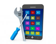 Mobile phone with wrench and screwdriver stock photo