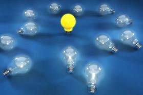 Multiple glass bulbs with one yellow bulb for leadership stock photo