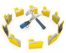 Multiple yellow folders in circle with hammer screwdriver in center stock photo