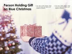 Person holding gift on blue christmas