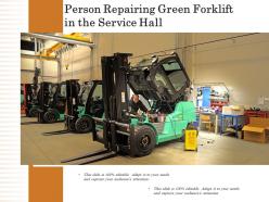 Person repairing green forklift in the service hall