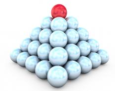 Pyramid of white balls and red on top leadership stock photo