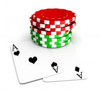 Red and green poker chips with two aces beneath stock photo