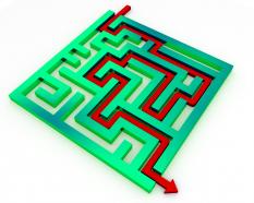 Red arrow for way out from green maze stock photo