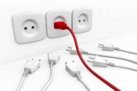 Red color plug in socket with multiple white plugs showing leadership stock photo