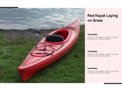 Red kayak laying on grass