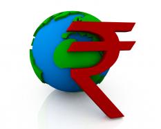 Red rupee symbol in front of globe stock photo