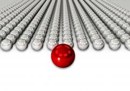 Red sphere as leader for silver chrome spheres as team stock photo