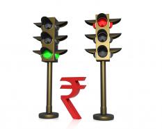 Rupee currency between two light signals stock photo