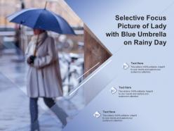 Selective focus picture of lady with blue umbrella on rainy day