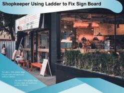 Shopkeeper using ladder to fix sign board