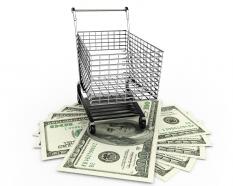 Shopping cart with dollars below the cart stock photo