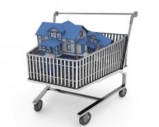 Shopping cart with houses for real estate and marketing stock photo