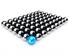 Silver metal balls with blue color ball in front as leader stock photo