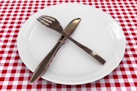 Spoon And Fork On Plate Over The Table Shows Food Stock Photo