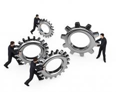 Team holding gears in hand for process control stock photo