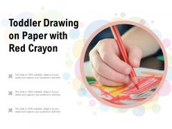 Toddler drawing on paper with red crayon