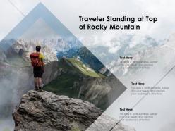Traveler standing at top of rocky mountain