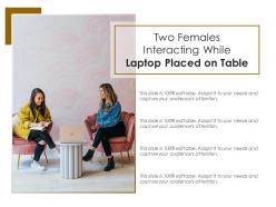 Two females interacting while laptop placed on table