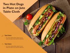 Two hot dogs in plate on jute table cloth
