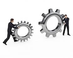 Two Man Holding Gears For Business Innovation Stock Photo