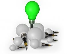 White bulbs with one green bulb as leader stock photo